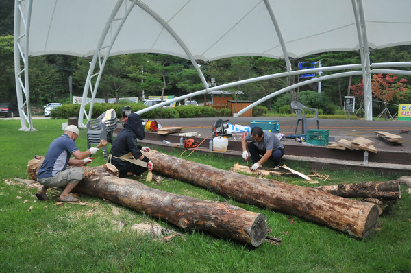 충북 옥천민예총 회원들이 커다란 나무를 깎아 장승을 만들고 있다.