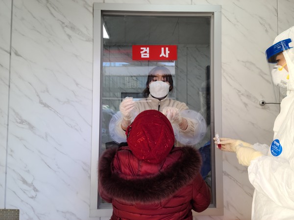 한 시민이 군보건소에 설치된 호흡기 전담클리닉 검체 채취실에서 검체를 하고 있다.