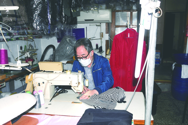 김만호 대표가 재봉틀로 옷을 수선하고 있다.