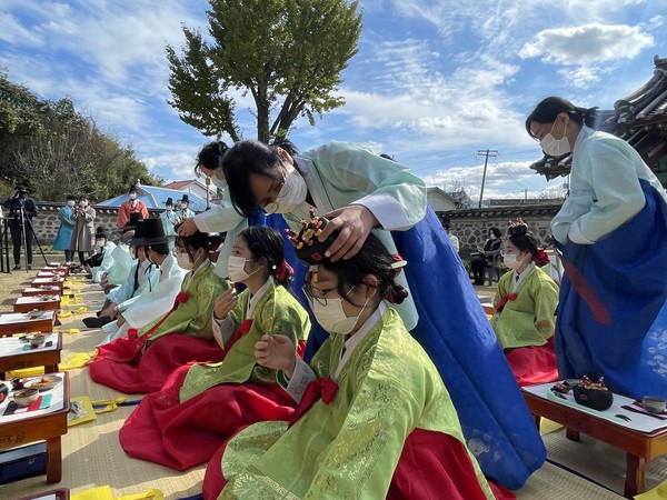 청산고등학교 학생들이 전통성년례 행사에서 전통의상을 입어 보고 있다.