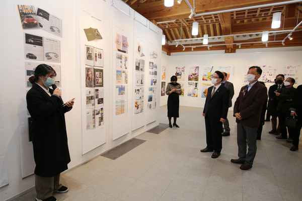 전시회에 참석한 관계자들이 작품을 감상하고 있다.