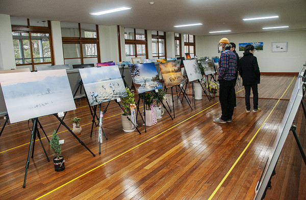 ‘빛그림이야기 회원전’이 열리고 있는 호평마루 생활문화센터 전시실에서 관람객들이 전시작품을 감상하고 있다.