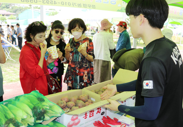 옥수수‧감자 축제장 판매 모습. 방문객들이 감자를 시식하고 있다.