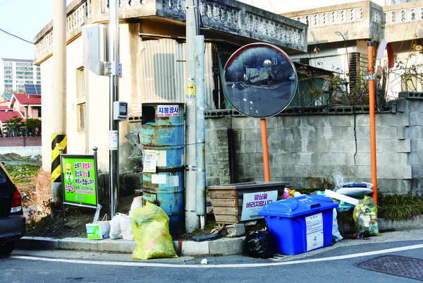 쓰레기 몸살은 젊음의 상징 대학길도 예외가 아니다. 분리수거함과 쓰레기통이 없는 골목에 쓰레기들이 여기저기 버려져 있다.