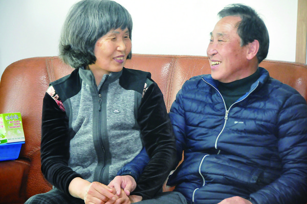 진순장 씨가 자신의 집 거실에서 아내를 바라보며 환하게 웃고 있다.
