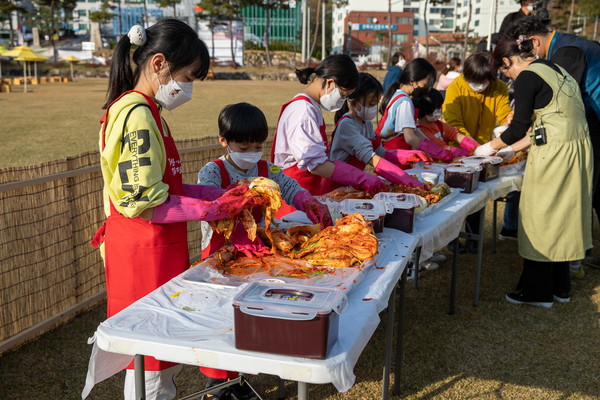 김장축제에 참가한 어린이들이 직접 김장을 담아보고 있다.