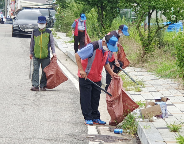 이원지역노인봉사대원들이 생활쓰레기를 줍고 있다.