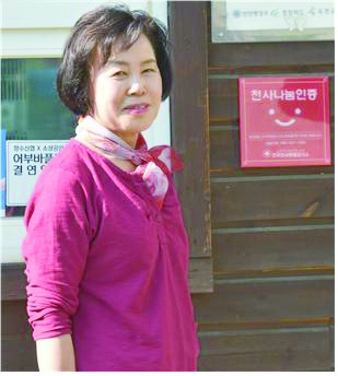 옥천숯불촌 김양금 대표가 천사나눔인정 표지판에서 촬영에 임하고 있다.